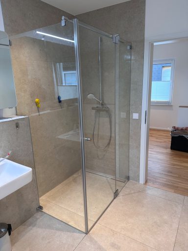 Moderne Dusche mit Glaswänden und minimalistischer Ausstattung in einem Badezimmer.